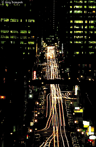 Langzeitbelichtung, die die Fahrzeugkolonnen in einer Straßenschlucht durch lange Lichtbänder deutlich amcht