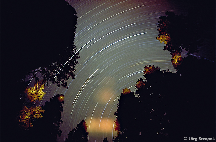 Langzeitbelichtung, die die scheinbare Bewegung der Sterne vor dem Nachthimmel zeigt
